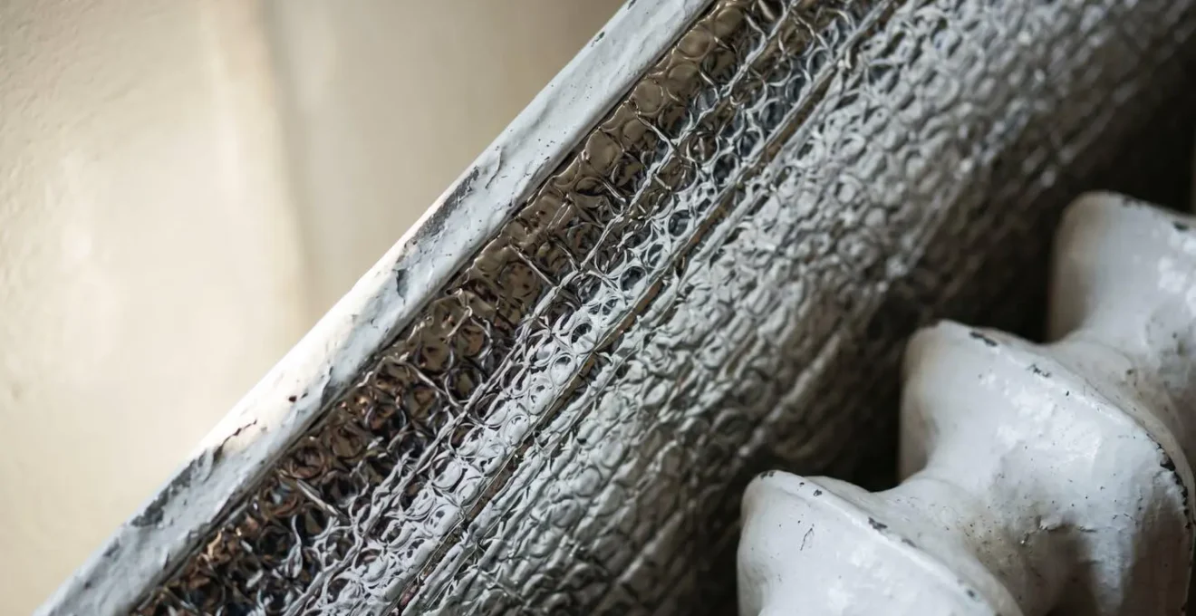 Installazione di un pannello termoriflettente dietro un termosifone in una casa italiana