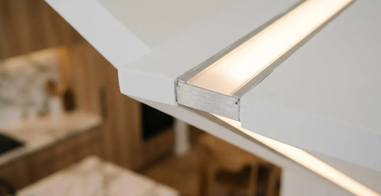 Dettaglio di profili LED integrati nel cartongesso di una cucina moderna